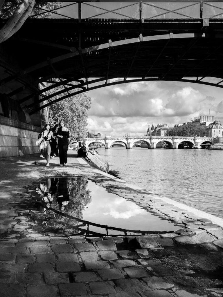 Reflections in a puddle under Pont des Arts in Paris