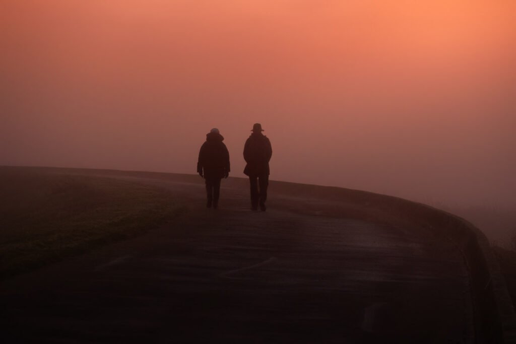 Two persons walking in the mist near the Lac du Der, Champagne, France.