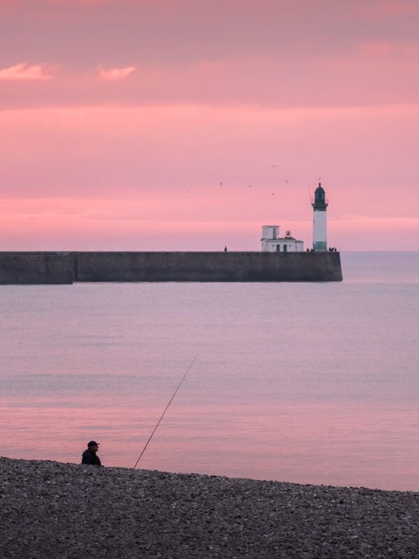 Pescador en la playa de Mers-les-Bains al atardecer