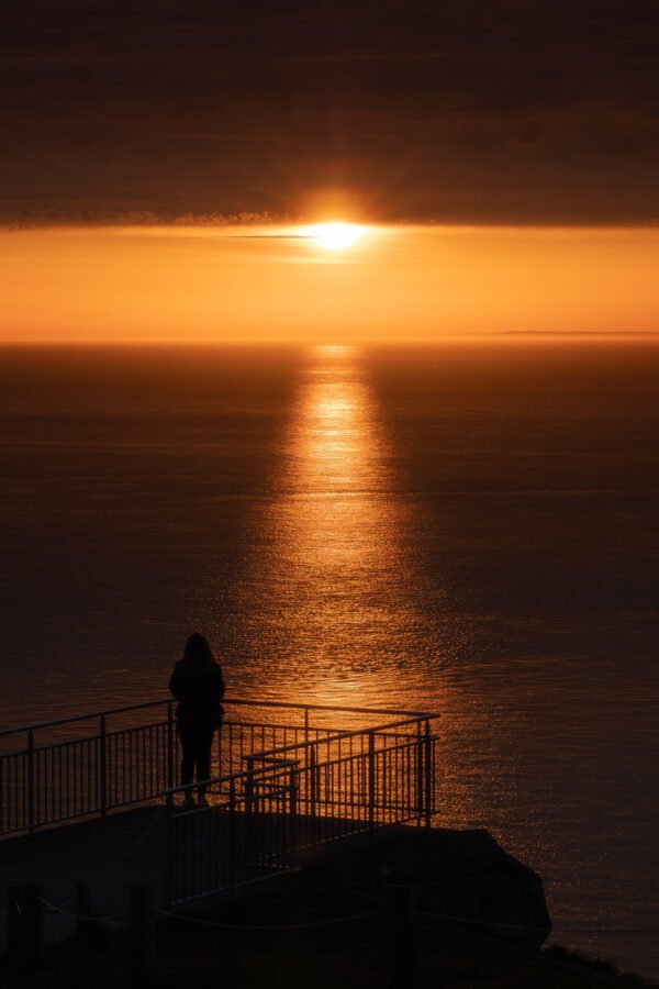 Femme regardant le coucher de soleil au cap Blanc-Nez, France
